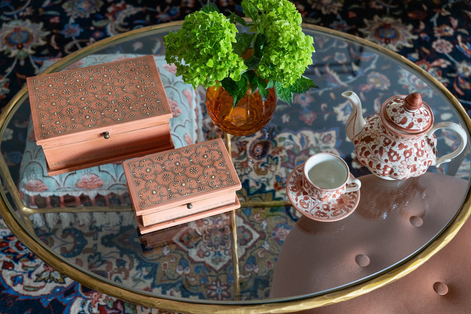 Round Glass Coffee Table With Boxes And Tea Pot And Tea Cup
